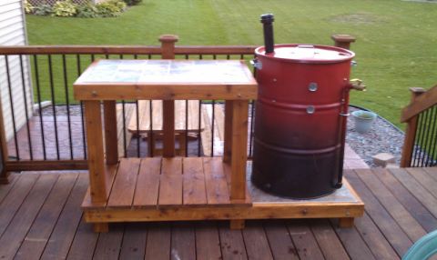 2008 Ford F-250 - A custom smoker drum and prep table setup on a wooden deck, with a grassy backyard visible in the background.