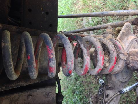 1979 Ford Bronco - Close-up of a vehicle's suspension coil spring, showing wear and paint markings.