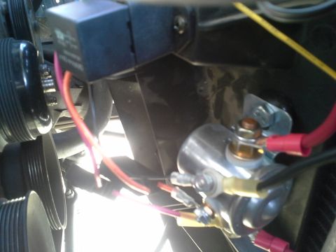 1991 Ford F-250 - Close-up of an under-hood relay, starter solenoid, and red wiring near a serpentine belt pulley.