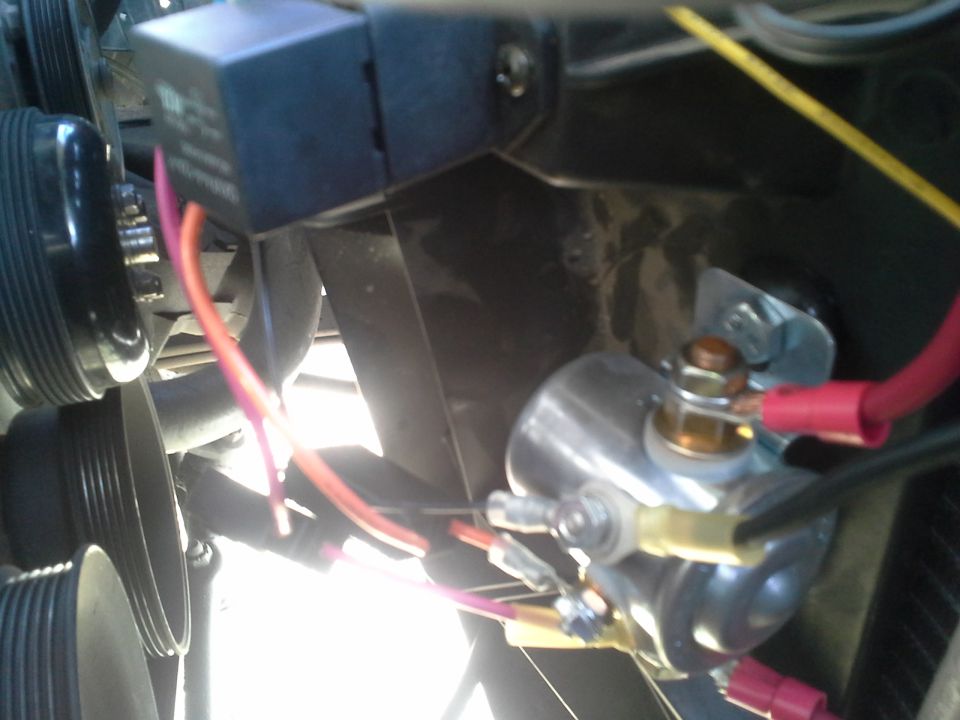 Close-up of engine bay relay, starter solenoid and red wiring on a vehicle