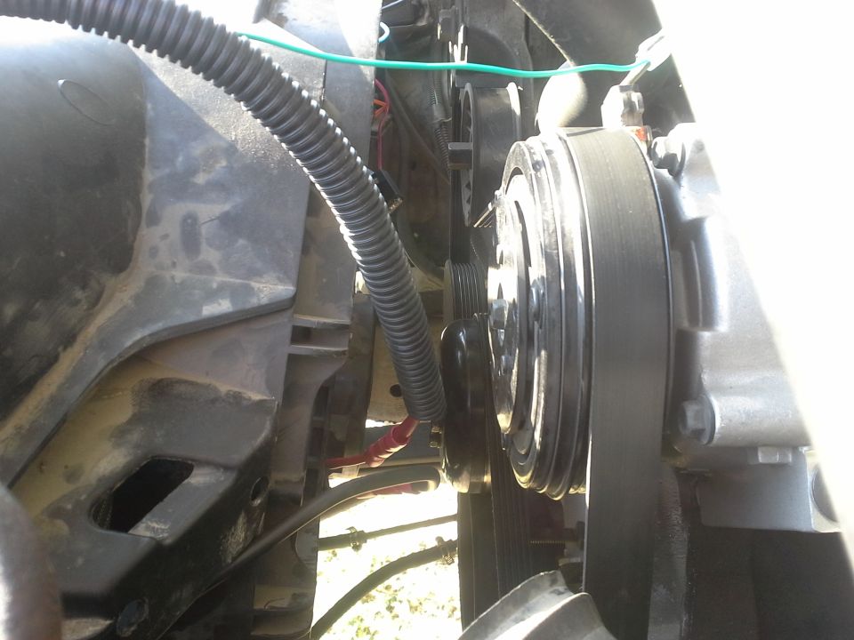 Close-up of engine belt and pulley system, possibly AC compressor
