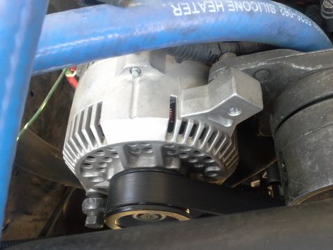 1991 Ford F-250 - Close-up of an alternator in a 1991 Ford F-250 engine bay, with a blue hose overhead.