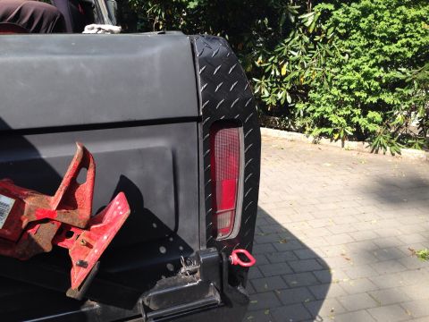 1979 Ford Bronco - Rear view of a 1979 Ford Bronco, showing diamond plate trim and a red jack.