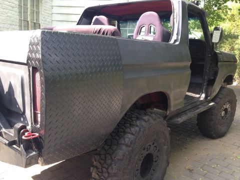 1979 Ford Bronco - This 1979 Ford Bronco features custom diamond plate rear quarter panels and racing seats, suggesting off-road modifications.