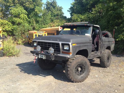1979 Ford Bronco - This modified Ford Bronco, likely from the late 1970s, is seen with two school buses in the background.