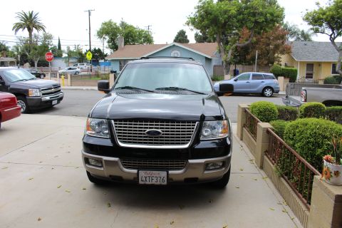 2003 Ford Expedition - A black 2003 Ford Expedition is parked in a driveway, with other vehicles visible in the background.