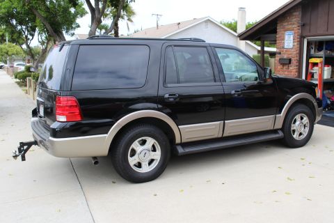 2003 Ford Expedition - Side view of a black 2003 Ford Expedition parked on a concrete driveway.
