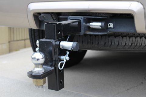 2003 Ford Expedition - The rear of a vehicle shows a trailer hitch assembly attached, with a spare tire mounted underneath.