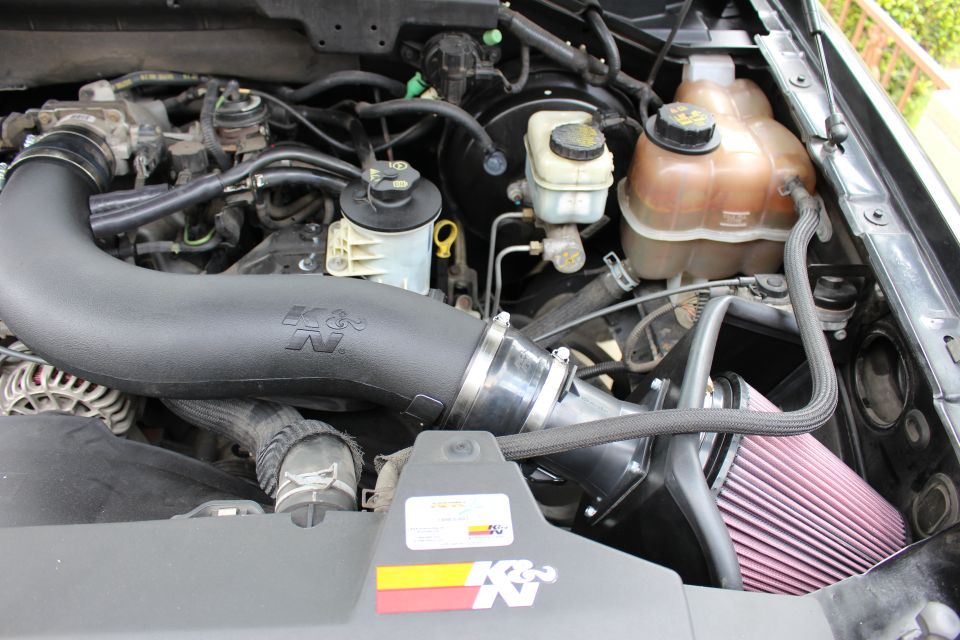 K&N air intake system installed in an engine bay, showing the filter and tubing
