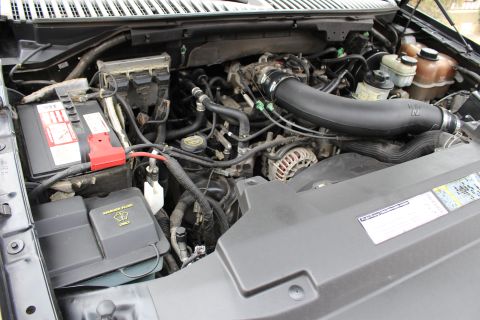 2003 Ford Expedition - The engine bay of a black Ford Expedition, showing the K&N air intake and battery. The model year appears to be 2004.