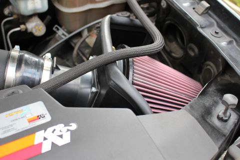 2003 Ford Expedition - Close-up of a K&N performance air intake system installed in a vehicle's engine compartment.
