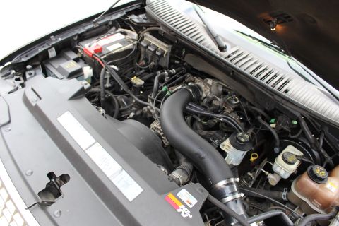 2003 Ford Expedition - The engine bay of a vehicle, showing various components and hoses, with a K&N sticker visible on a cover.