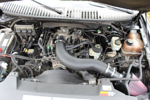 2003 Ford Expedition - Close-up view of an engine bay an aftermarket K&N air intake system and other engine components.