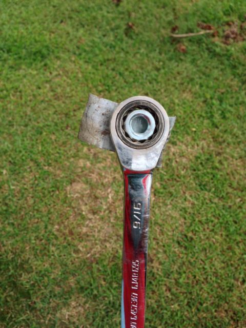1979 Ford Bronco - A close-up shows a ratchet wrench holding a bearing, with grass in the background.
