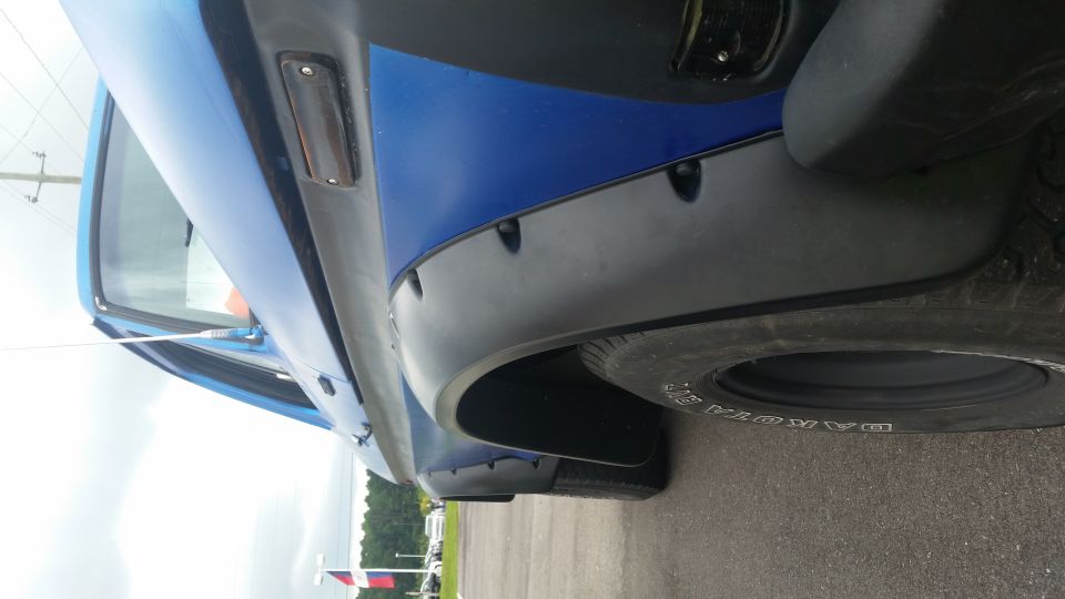 Blue SUV fender and tire with black fender flares