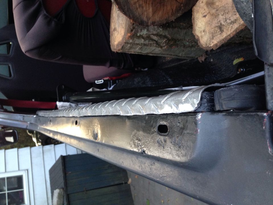 Vehicle interior showing diamond plate trim, seat fabric, and logs