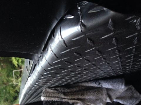 1979 Ford Bronco - Close-up view of diamond plate metal installed under a vehicle, with the Supermotors.net logo in the corner.