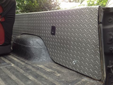 1979 Ford Bronco - Diamond plate bed liner and wheel well detail in a truck bed.