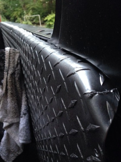 1979 Ford Bronco - Close-up of a diamond plate bedliner, with a towel visible on the left side.