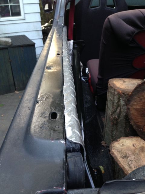 1979 Ford Bronco - The interior of a vehicle is shown, with logs loaded in the cargo area and a roll bar visible.