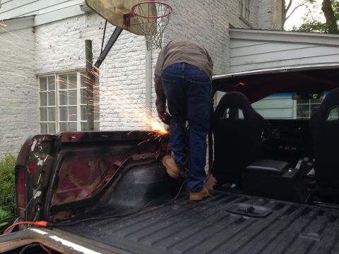1979 Ford Bronco - A person is welding the rear of a red 1978 Ford Bronco, which has racing seats installed.
