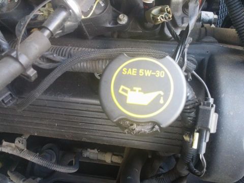 2000 Mercury Grand Marquis - Close-up of an engine oil cap indicating SAE 5W-30 viscosity.