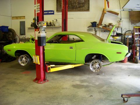 1974 Dodge Challenger - A lime green 1974 Dodge Challenger is shown on a lift in a garage, with its hood and trunk open for service.