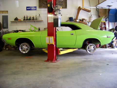 1974 Dodge Challenger - A lime green 1974 Dodge Challenger is shown on a lift in a garage, undergoing maintenance.