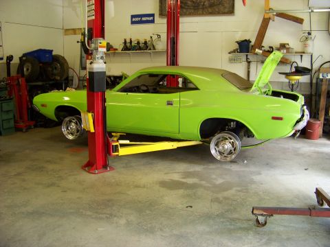 1974 Dodge Challenger - Lime green 1974 Dodge Challenger undergoing service on a car lift in a workshop.
