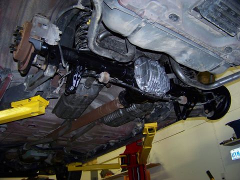 1999 Mercury Grand Marquis - The underside of a vehicle is shown elevated on a lift, revealing its mechanical components.