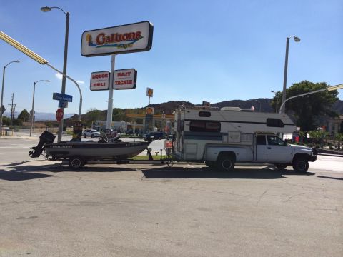 1997 Dodge 3500 - Truck camper and boat trailer combination seen at a gas station.