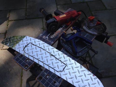 1979 Ford Bronco - Tools and a metal sheet are laid out on a patio, suggesting a fabrication project is underway.