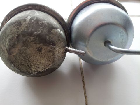1976 Ford Ranchero - Comparison of a worn vacuum actuator next to a new one the Ford logo.