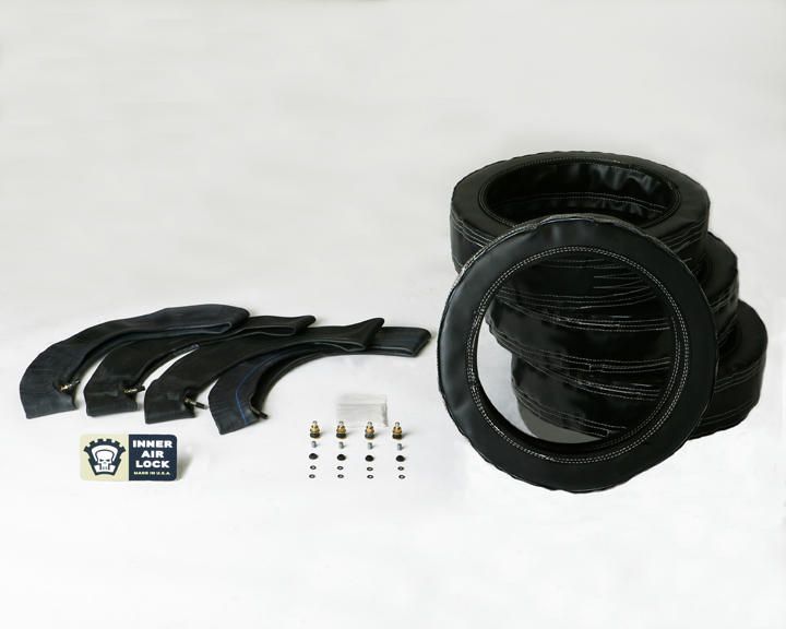 Four black inner tubes and four valve stems with a stack of black tire covers