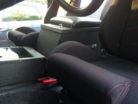 1979 Ford Bronco - The interior of the vehicle features black seats with red stitching and a custom center console.