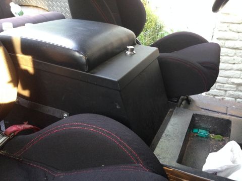 1979 Ford Bronco - Interior view of a vehicle, showing black seats and a center console with red stitching.