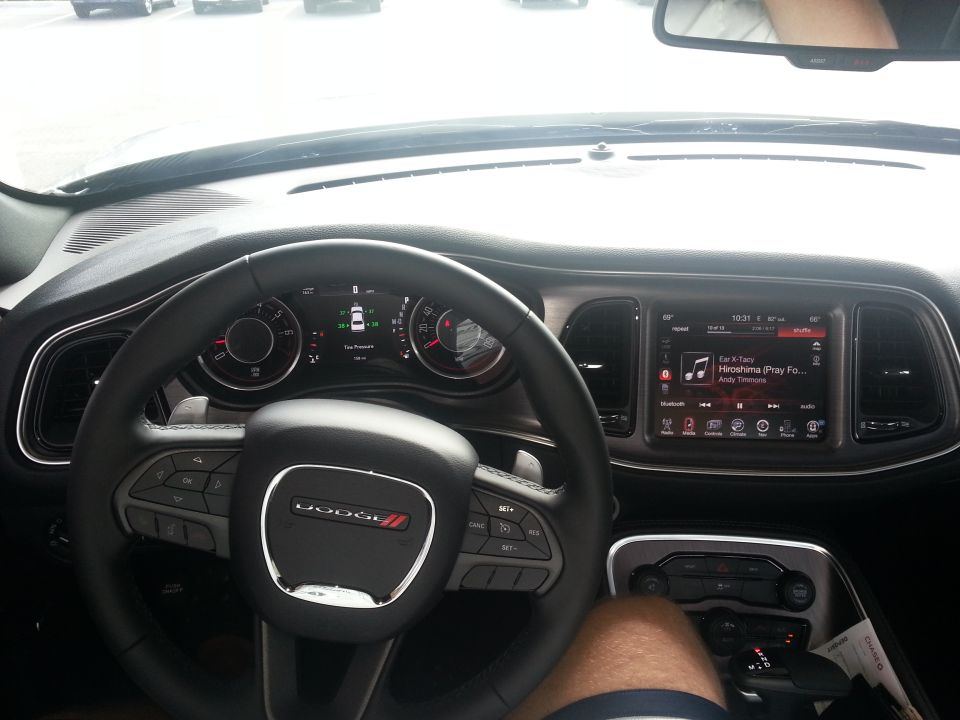 2015 Dodge Challenger interior with infotainment screen showing music and digital gauges