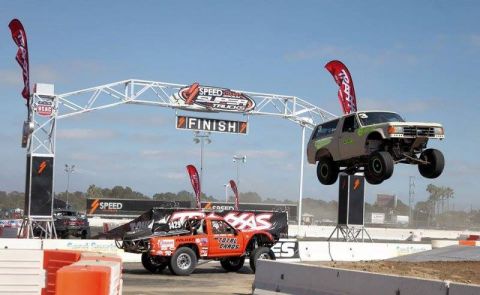 1968 Ford Mustang - Off-road trucks compete in a race, with one vehicle airborne at the finish line.