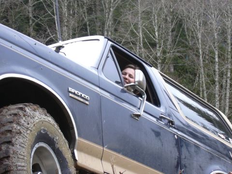 1991 Ford Bronco - A person smiles from the driver's seat of a dark blue 1991 Ford Bronco.