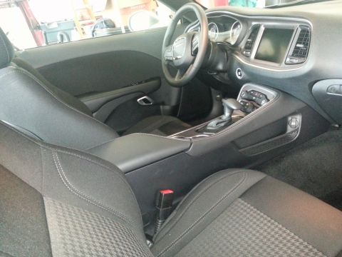 2015 Dodge Challenger - The interior of a 2015 Dodge Challenger features black cloth seats with a houndstooth pattern and a modern dashboard layout.