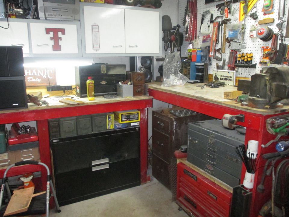 Workbench with red trim, pegboard wall, tools, and filing cabinet