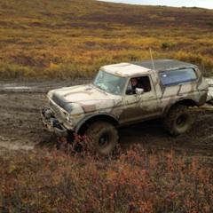 1990 Ford F-250 - This Ford Bronco, likely a 1978 or 1979 model, navigates a muddy terrain.