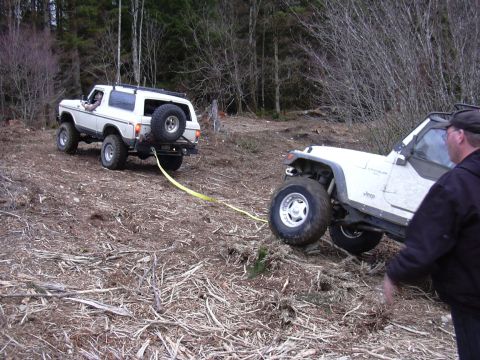 1991 Ford Bronco - A 1991 Ford Bronco is being towed by a Jeep Wrangler on a wooded trail.