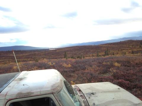 1990 Ford F-250 - A white truck sits in a vast landscape with rolling hills covered in autumn colors under a cloudy sky.