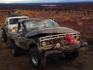 1990 Ford F-250 - A heavily damaged pickup truck sits in a rural landscape with another vehicle behind it.