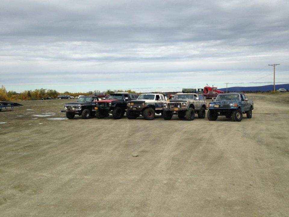 Line of lifted off-road trucks parked in a lot