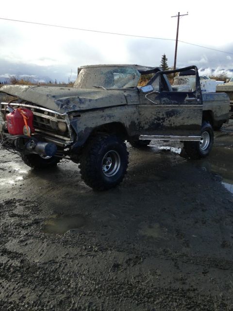 1990 Ford F-250 - This heavily damaged truck is covered in mud, with a gas can mounted on the front bumper.