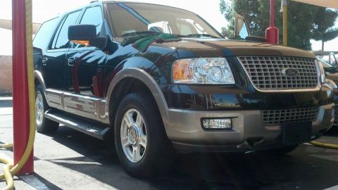 2003 Ford Crown Victoria - Black Ford Expedition SUV with two-tone lower cladding and alloy wheels parked under a shaded canopy.