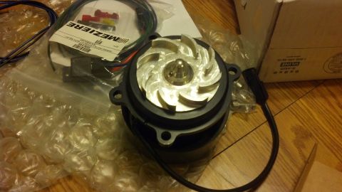 2003 Ford Crown Victoria - Close-up of a Meziere electric water pump showing its polished aluminum impeller, body and attached wiring on a floor.