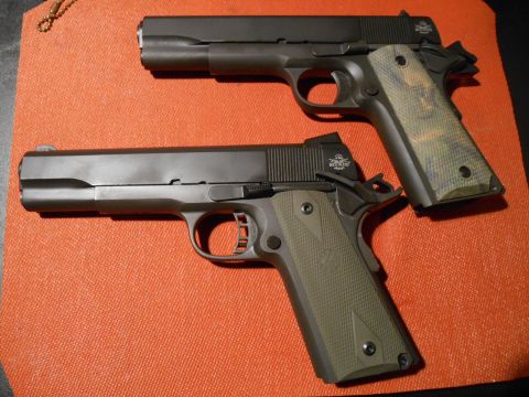 1994 Ford Bronco - Two handguns, one with green grips and the other with camouflage grips, are displayed on an orange textured surface.